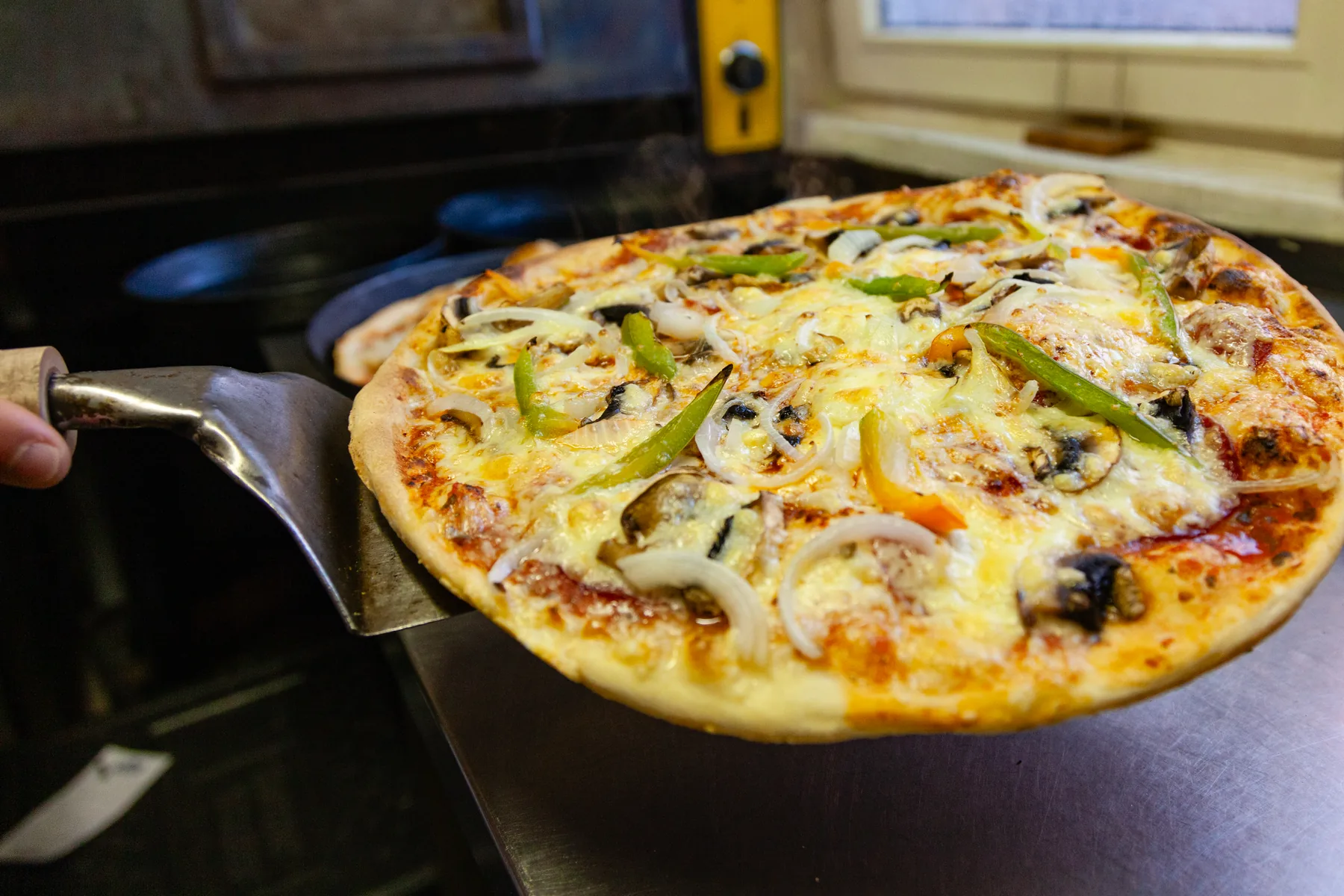 Pizza frisch aus dem Ofen auf dem Pizzaschieber
